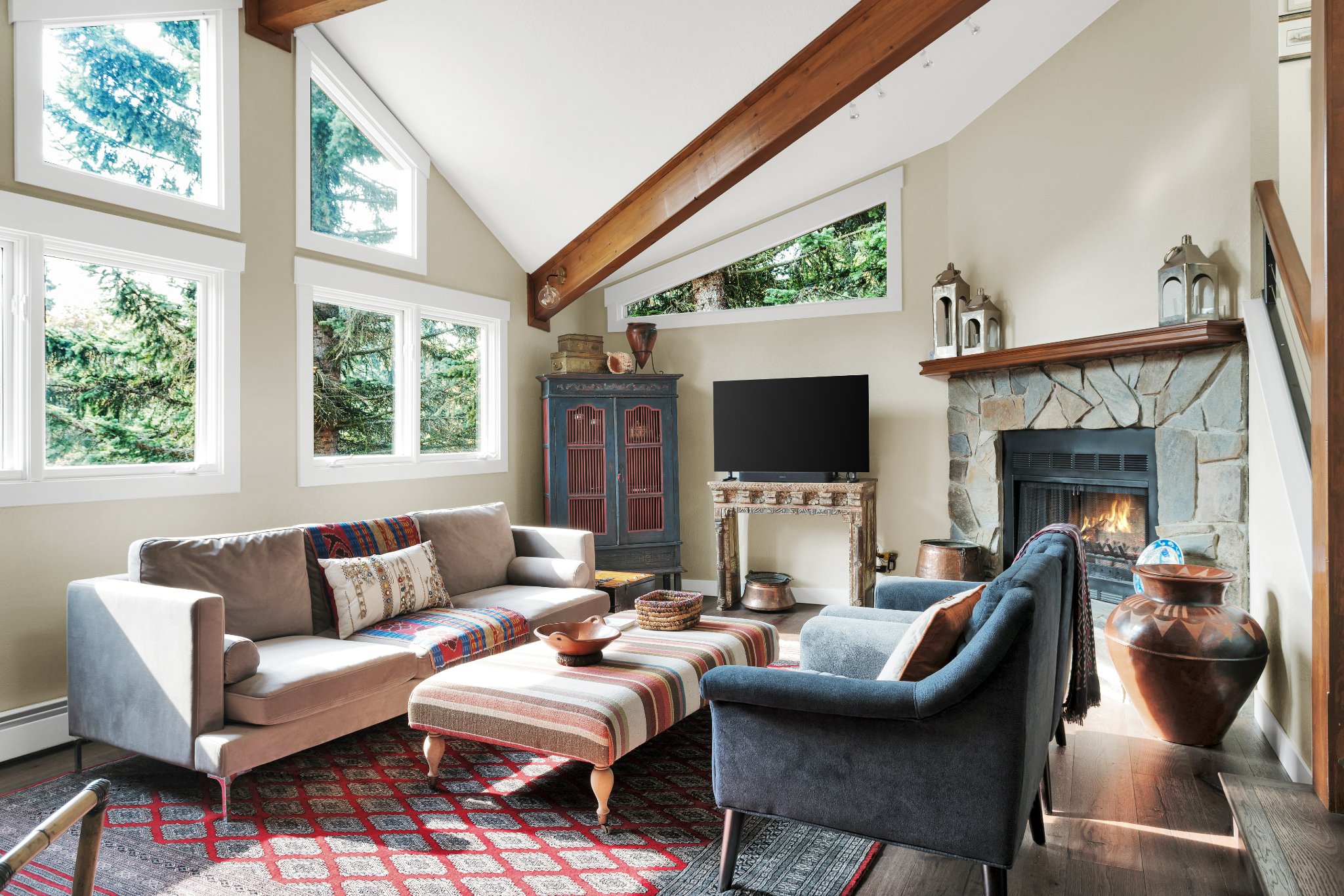 A vaulted ceiling and large windows create a luxurious living room space.