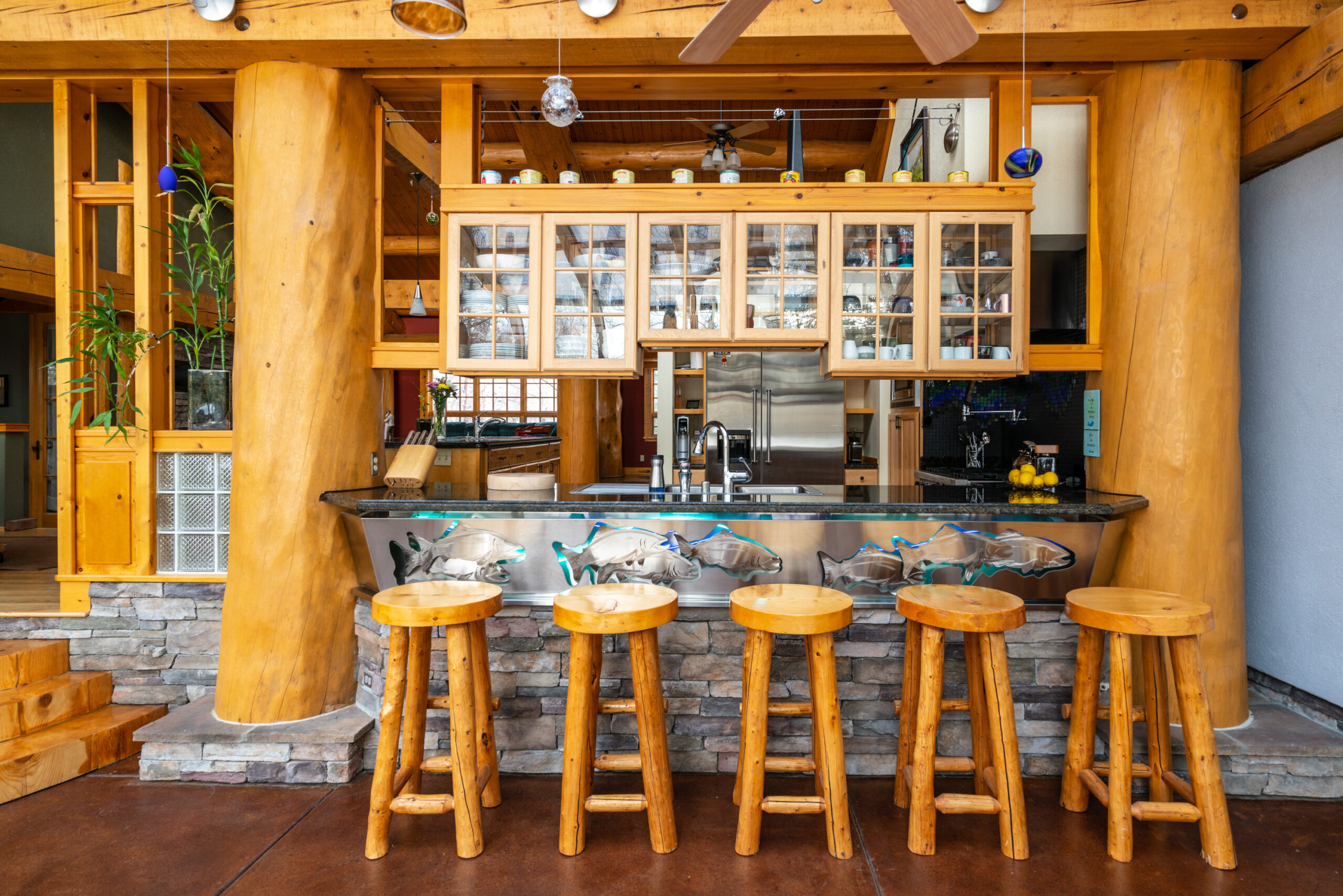Breakfast bar and wooden stools inside rustic timber framed home.